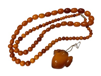 Lot 168 - Vintage amber bead necklace and carved amber pendant