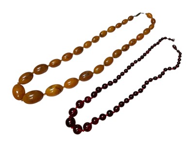 Lot 171 - Vintage simulated amber bead necklace, 61cm long and a simulated cherry amber bead necklace, 54cm long (2)