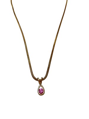 Lot 297 - Pink sapphire pendant with a round mixed-cut pink sapphire measuring approximately 3.2mm diameter in 18ct gold setting on 9ct gold snake link chain.
