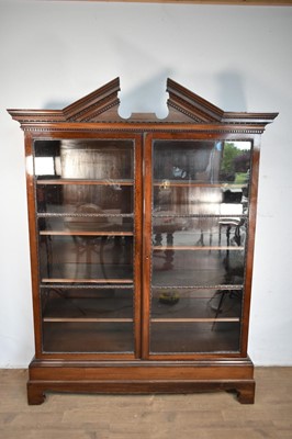 Lot 1314 - Early 20th century Chippendale revival mahogany bookcase, with angular dentil cornice, with adjustable shelves enclosed by pair of glazed doors, on bracket feet, 150cm wide x 40cm deep x 205cm h...