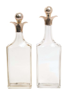 Lot 505 - Two early 20th century glass decanters of rectangular form, attributed to Christopher Dresser, with facet cut necks and silver collars and stoppers, (Birmingham 1909/1918), maker Hukin & Heath.
