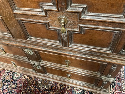 Lot 1262 - 17th century oak geometric chest with an arrangement of four long drawers, each with brass drop handles, on turned bun feet