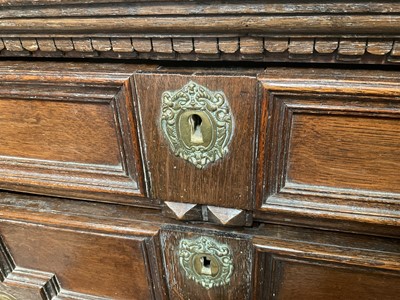 Lot 1262 - 17th century oak geometric chest with an arrangement of four long drawers, each with brass drop handles, on turned bun feet