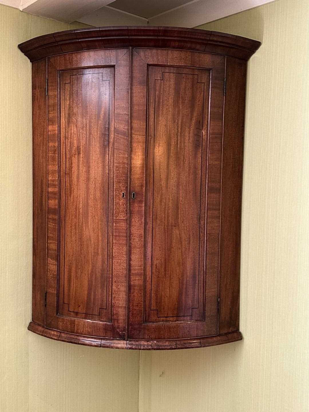 Lot 1266 - George III mahogany bow front hanging corner cupboard with inlaid ebony stringing, 105cm high