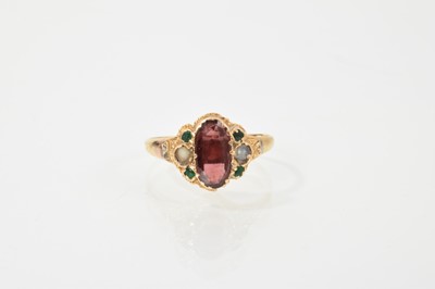 Lot 462 - Victorian gold and gem-set ring with an oval mixed-cut garnet flanked by two pearls and four green stones, engraved shoulders on later shank, ring size K.