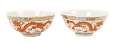 Lot 15 - Pair of Chinese porcelain bowls, 19th / 20th century, finely decorated in enamels with dragons chasing the pearl amongst clouds, waves below and a Greek key border, iron-red six character Guangxu...