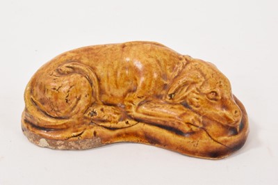 Lot 30 - Chinese amber glazed pottery model of a dog, amber-straw glaze, possibly Tang Dynasty. Cf: For a similar example see Kaifeng City Museum collection. For a similar example of an amber glazed piec...