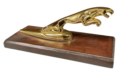 Lot 13 - Jaguar Cars, gold plated leaping cat car mascot, mounted on wooden plinth, approximately 17cm in overall length.