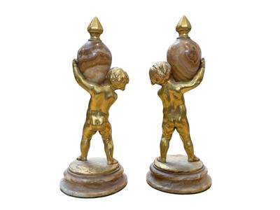 Lot 5070 - Pair of Continental figures of putti holding obelisks, on marble bases.
