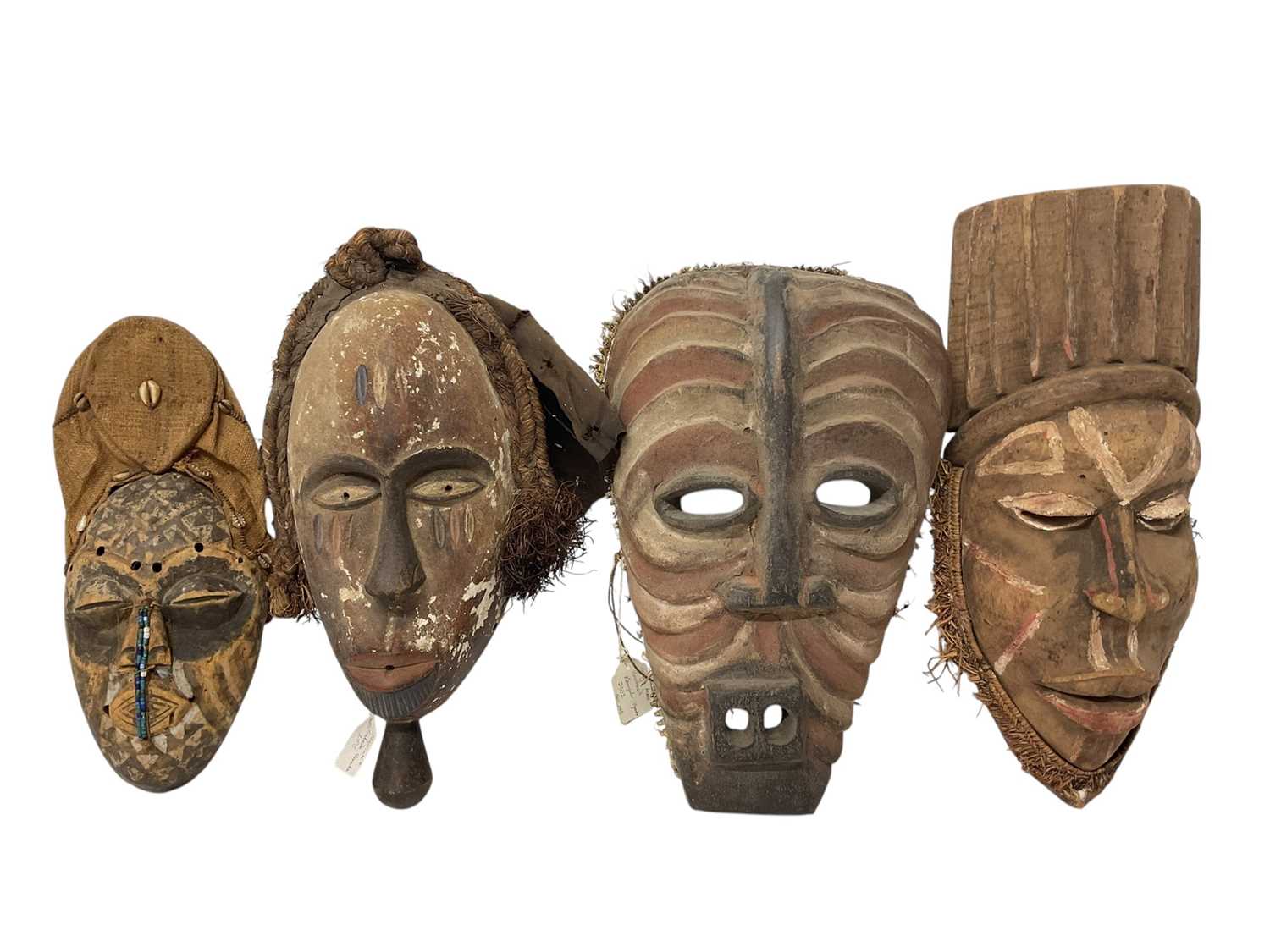 Lot 753 - Four African tribal masks, including a Kuba mask with shell, cloth and bead ornament, Yoruba mask, Fang mask and a polychrome painted Basonge mask. (4)