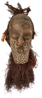 Lot 754 - Antique Kuba Pwoom Itok mask, with stylised features and white pigment, with feathers and raffia, the wooden part approximately 48cm high