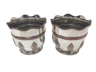 Lot 455 - Pair of late Victorian silver plated wine coolers / jardinières with gadrooned borders and applied panels of scroll decoration, each 17.8cm in overall height.