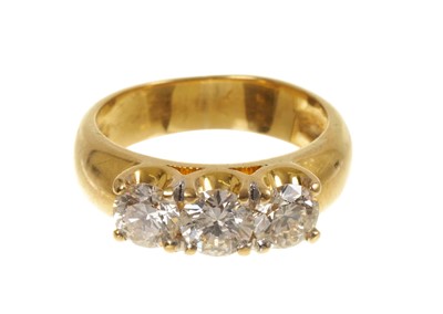 Lot 454 - Diamond three-stone ring with three brilliant cut diamonds in four claw setting on wide yellow gold shank. Estimated total diamond weight approximately 1.50cts
