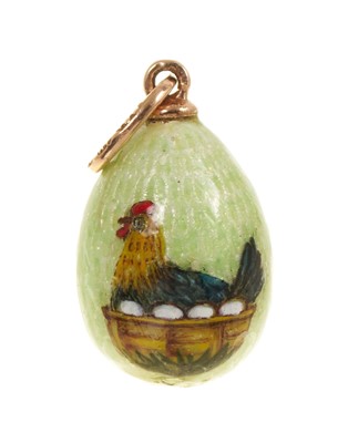 Lot 483 - Russian gold and guilloché enamel egg pendant depicting a hen sitting on a basket of eggs, on green ground, the gold mount with Fabergé marks