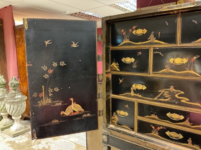 Lot 1522 - Late 17th / early 18th century Chinese lacquer cabinet on stand, the twin hinged doors decorated with landscapes, brass strap hinges, enclosing an arrangment of drawers, on square legs