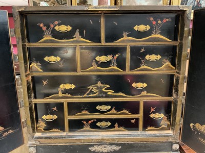 Lot 1522 - Late 17th / early 18th century Chinese lacquer cabinet on stand, the twin hinged doors decorated with landscapes, brass strap hinges, enclosing an arrangment of drawers, on square legs