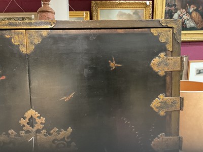 Lot 1522 - Late 17th / early 18th century Chinese lacquer cabinet on stand, the twin hinged doors decorated with landscapes, brass strap hinges, enclosing an arrangment of drawers, on square legs