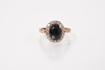 Lot 638 - Sapphire and diamond cluster ring with an oval mixed cut blue sapphire surrounded by a border of single cut diamonds in claw setting on 9ct gold shank