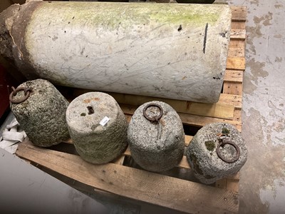 Lot 1934 - Four antique granite weights, three with cast iron rings, 24cm high
