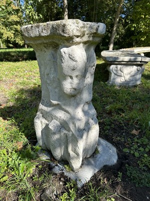 Lot 1935 - Pair of 17th / 18th century carved stone mounts, each with winged cherubic figures, approximately 70cm high, set into a concrete base