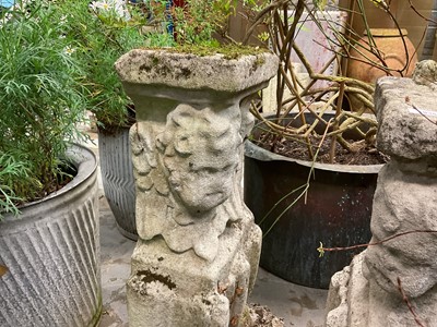 Lot 1935 - Pair of 17th / 18th century carved stone mounts, each with winged cherubic figures, approximately 70cm high, set into a concrete base