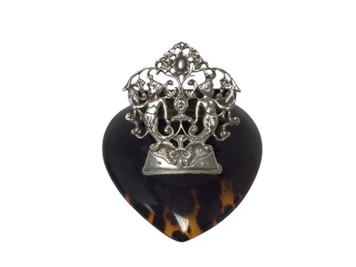 Lot 492 - Edwardian silver letter clip with pierced figural decoration, on a heart shaped tortoiseshell base, 12cm in overall length.