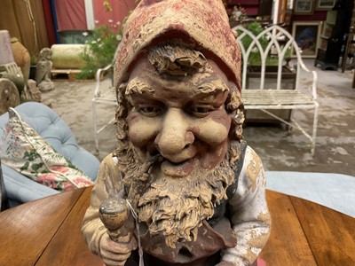 Lot 1259 - Antique German terracotta garden gnome, in seated repose, with pipe