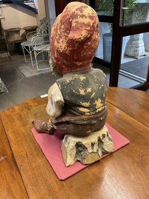 Lot 1259 - Antique German terracotta garden gnome, in seated repose, with pipe