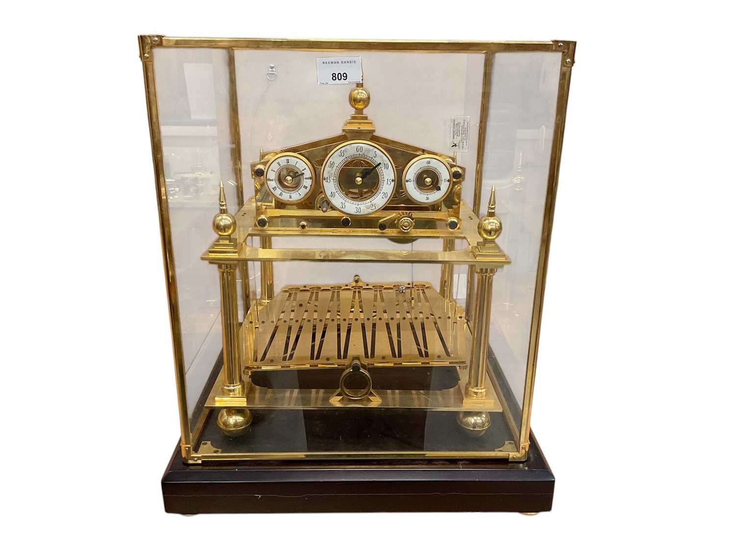Lot 809 - Impressive Chinese Congreve-style rolling ball clock with enamel dials in glazed brass framed case 49 x 37 x 37 cm with key