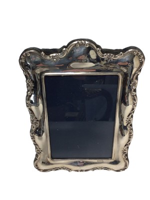 Lot 507 - Contemporary silver photograph frame of rectangular form with scroll borders and easel support, (Sheffield 1992), maker Mappin & Webb, 21 x 14.5cm overall.