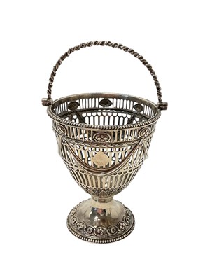 Lot 470 - Georgian silver sugar basket with pierced decoration, rope twist borders and central swing handle, the base stamped with maker's mark only, 4.12ozs, 10cm in height (excluding handle).
