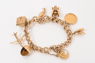 Lot 554 - 9ct gold charm bracelet with a collection of gold and yellow metal charms to include an Austrian 1892 gold coin.