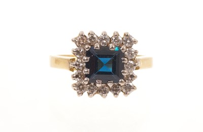 Lot 454 - Sapphire and diamond cluster ring with a square cut blue sapphire