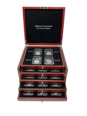 Lot 430 - U.S. - A five drawer wood cabinet containing a Danbury Mint Collection of PCS 'Plastic Slabbed' brilliant UNC silver Dollars to include 1878, 1879, 1880, 1881, 1882, 1883, 1884, 1885, 1886, 1887...