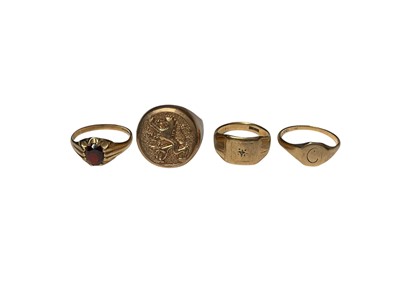 Lot 191 - Four 9ct gold rings to include a garnet ring, rampant lion ring and two signet rings