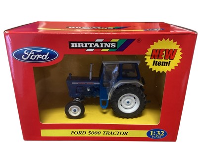Lot 1711 - Britains diecast 1:32 Scale Tractors including Ford 5000 #42196, Ford 7000 #42197, New Holland TN75DA # 42021 and Massey Ferguson 6140 #09449, in window boxes (4)
