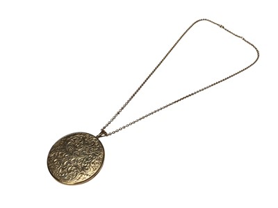 Lot 135 - 9ct gold large circular locket pendant with engraved decoration on 9ct gold chain