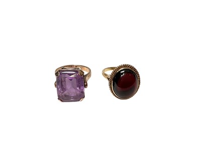 Lot 140 - 1970s amethyst cocktail ring and a garnet cabochon ring both in yellow metal settings (2)