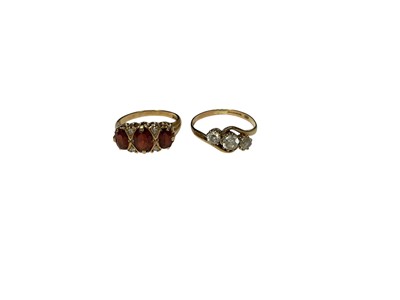 Lot 241 - 9ct gold garnet three stone ring, size M and 9ct gold synthetic white three stone cross over ring, size O½ (2)