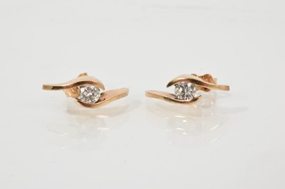 Lot 428 - Pair of diamond stud earrings in gold cross over settings