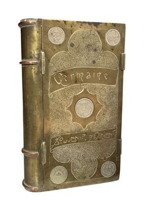 Lot 777 - Interesting First World War brass trench art trinket box in the form of a book engraved 'Germaine Souvenir D' Orient', and set with various coins, 18.2cm in length.
