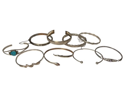 Lot 119 - Nine silver bangles including two snake bangles, torque bangle set with a turquoise stone, hinged bangles etc