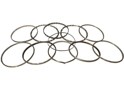 Lot 120 - Eleven silver bangles, mostly plain and some with twisted / engraved decoration