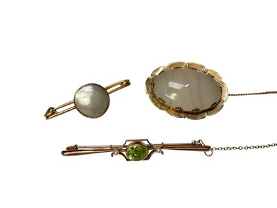 Lot 221 - Edwardian 9ct gold peridot and seed pearl bar brooch and two Edwardian yellow metal mounted brooches (3)