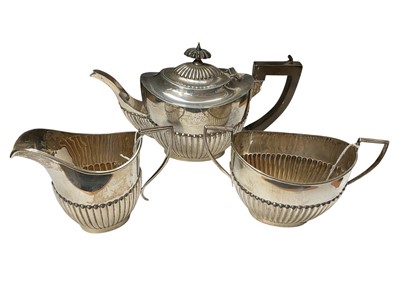 Lot 184 - Edwardian and later silver composite three piece teaset, comprising teapot with fluted decoration, (Birmingham 1905), together with similar milk jug, (Birmingham 1911) and sugar bowl, (Birmingha...