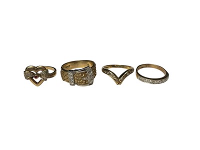 Lot 276 - 9ct gold diamond set buckle ring, 9ct gold diamond half eternity ring, 9ct gold wishbone ring and a yellow metal ring (4)