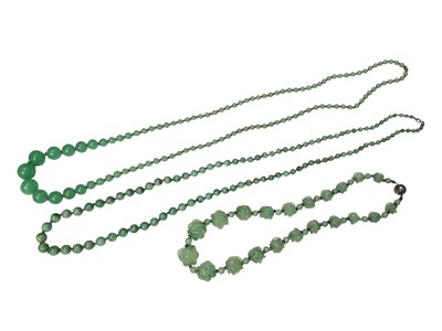 Lot 283 - Vintage jade / green hardstone graduated bead necklace, another similar with carved beads and a green glass bead necklace (3)