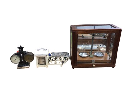 Lot 3073 - Chemical balance scales in a oak and glazed case, combined barometer and clock in a cast iron case on a marble stand and a Casella Thermohygrograph