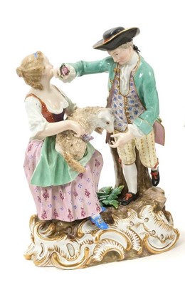 Lot 5 - 18th / 19th century Meissen porcelain group of a couple, the woman seated with a lamb on her lap, the man standing over her with a flower, on a gilt rococo scroll base, crossed swords and incised...
