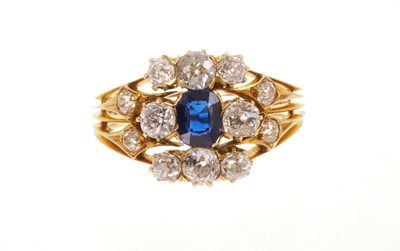 Lot 512 - Victorian sapphire and diamond cluster ring with an oval mixed cut blue sapphire measuring approximately 5.5mm x 4.6 x 2.7mm surrounded by eight old cut diamonds in gold claw setting flanked by...